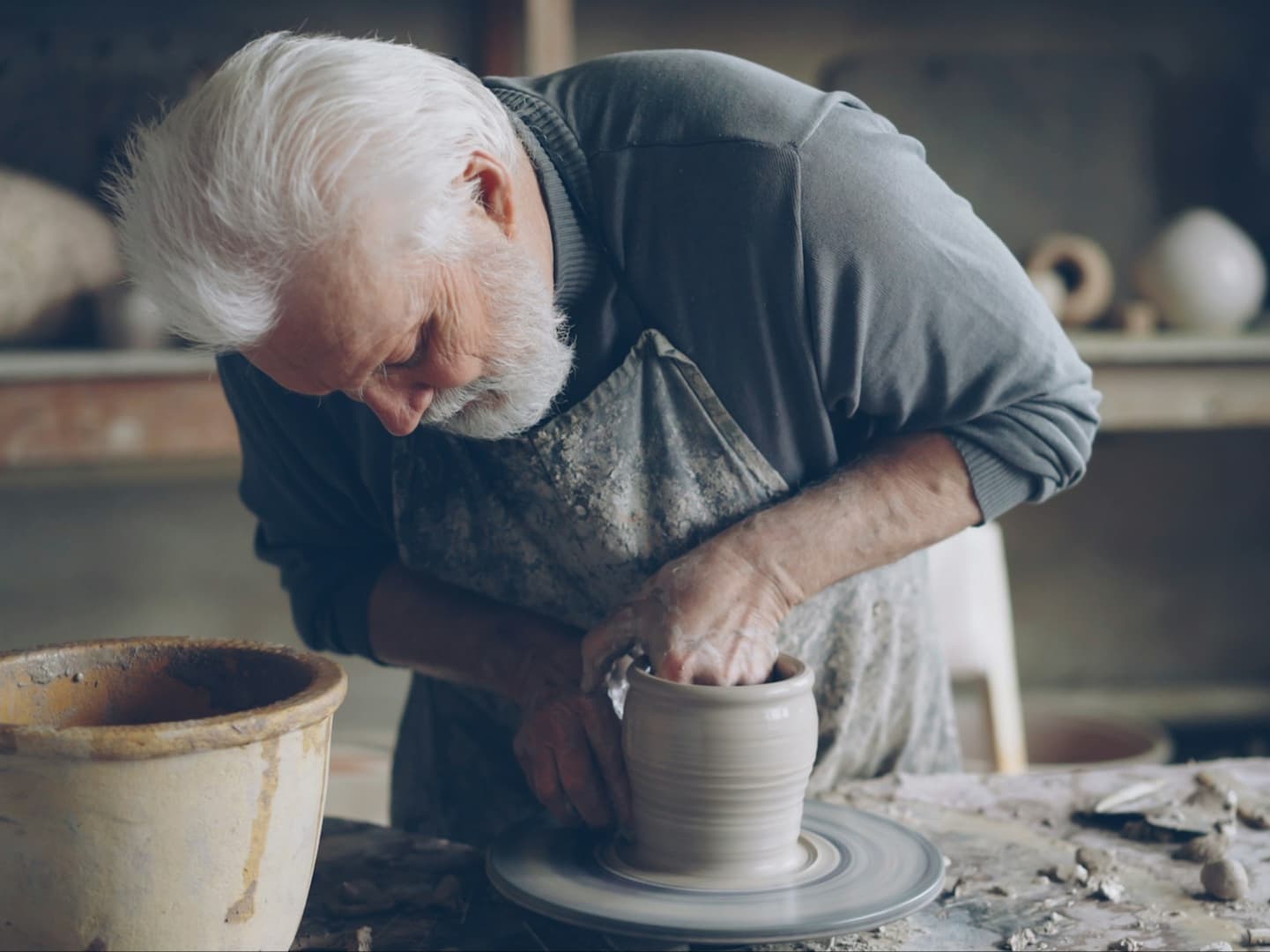 An older man working on pottery
